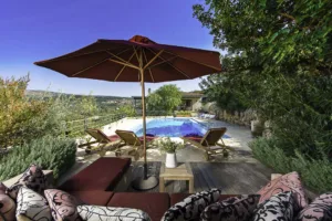 Villa Levanda's pool terrace with sun loungers, parasol and cushioned seating