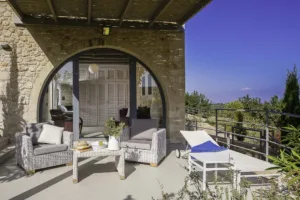 Villa Levanda's stone-arched lower terrace with wicker seating and a lounger