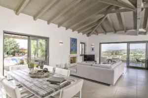 Villa Levanda's open-plan living and dining room under a high wooden ceiling