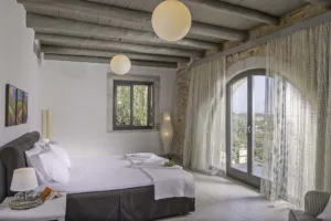 Master bedroom at Villa Levanda with a stone arch and doors to a private balcony
